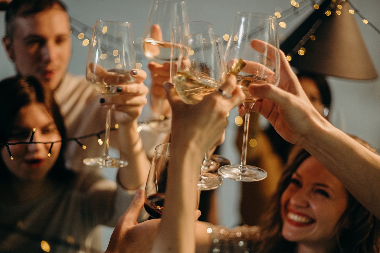 A group of friends joyfully toasting with champagne glasses at a festive celebration.