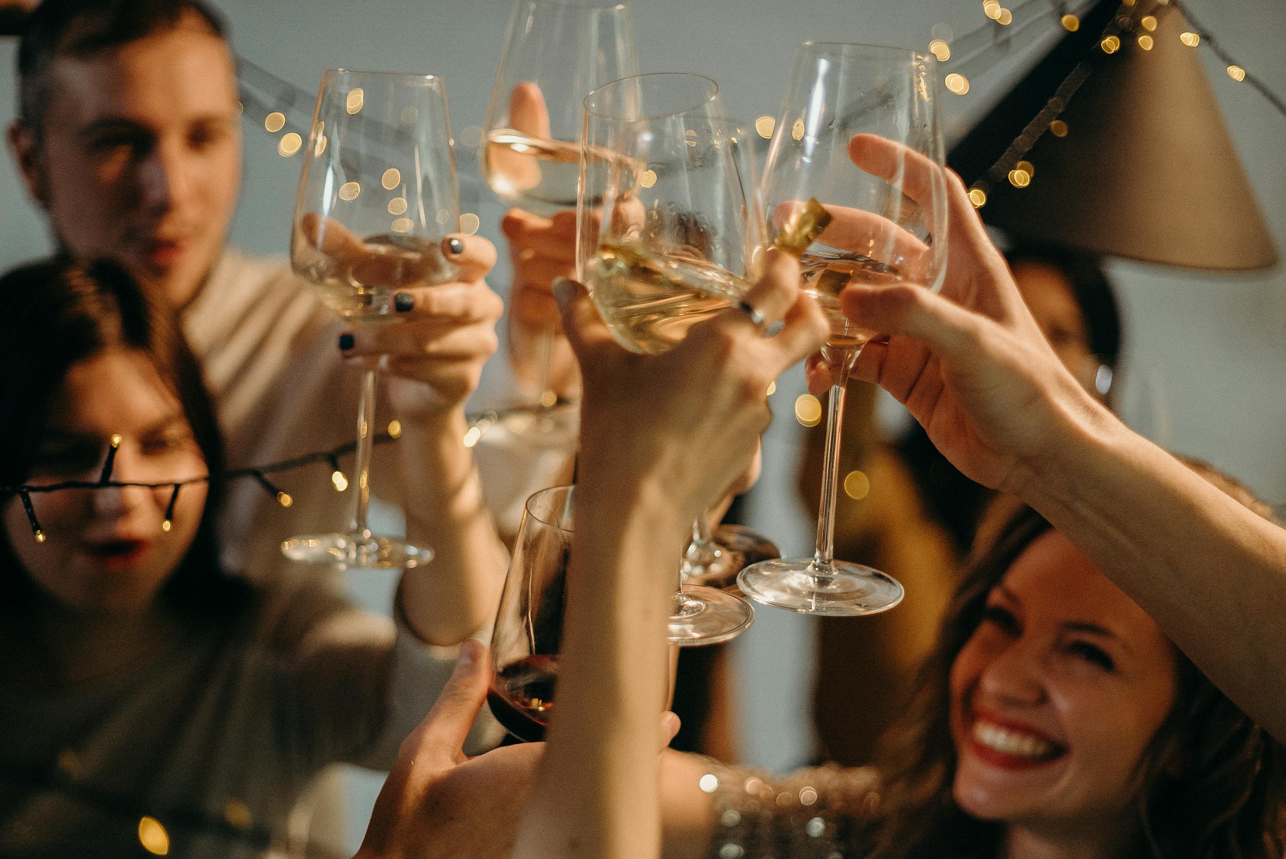 A group of friends joyfully toasting with champagne glasses at a festive celebration.